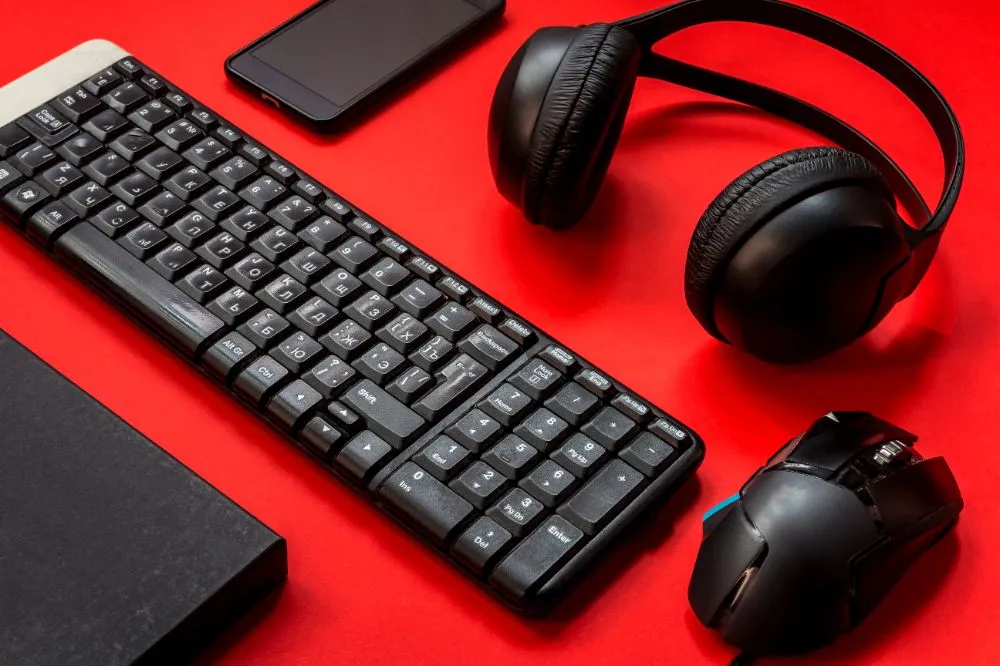 keyboard, headphones and mouse on a red background