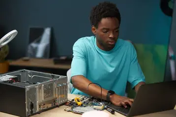 IT technician repairing a desktop computer in a repair workshop
